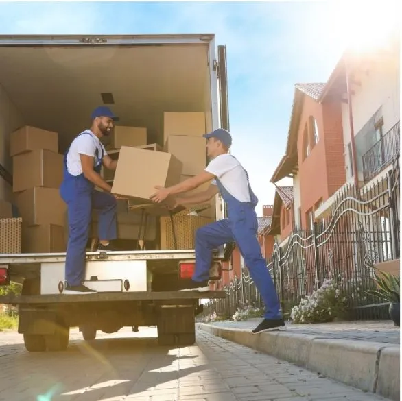 Movers loading boxes into a moving truck at a residence
