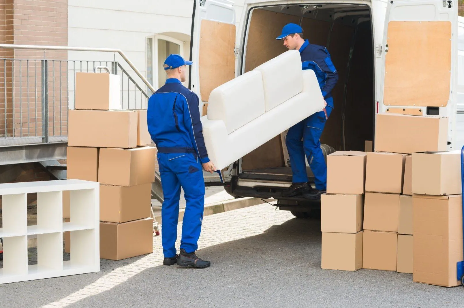 Movers carrying a sofa from a van